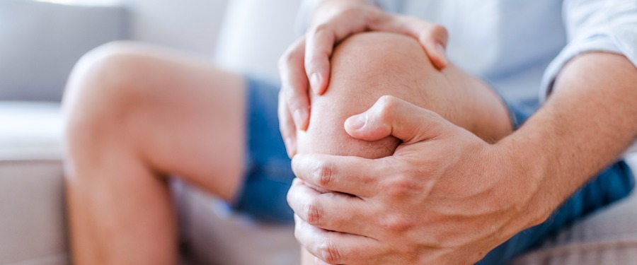 Man experiencing osteoporosis or osteoarthritis pain in the knee Man experiencing osteoporosis or osteoarthritis pain in the knee