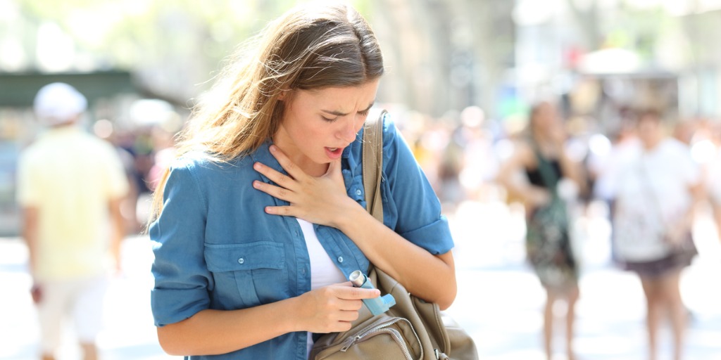 asthmatic-girl-suffering-an-attack-and-searching-inhaler-picture-id1030853356