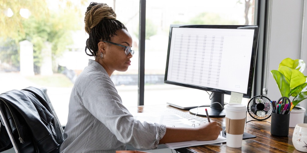 A mid adult African American businesswoman concentrates while working in her office.