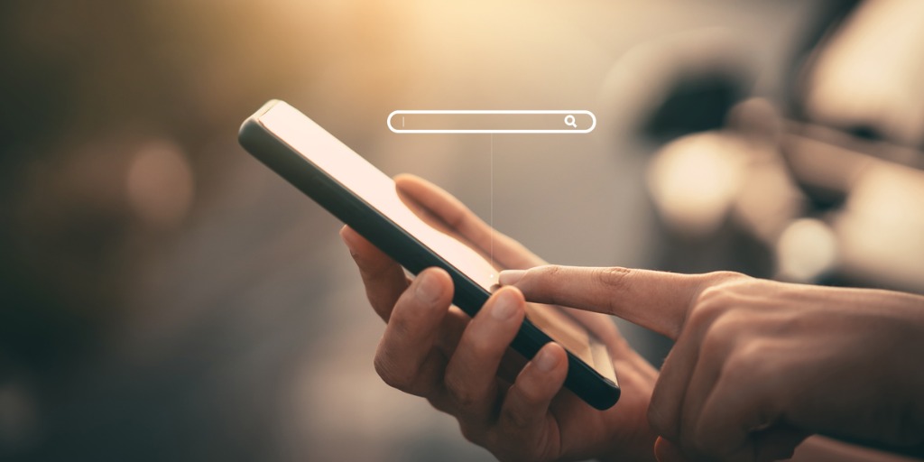 Close-up of a hand using the search function of a smartphone Close-up of a hand using the search function of a smartphone