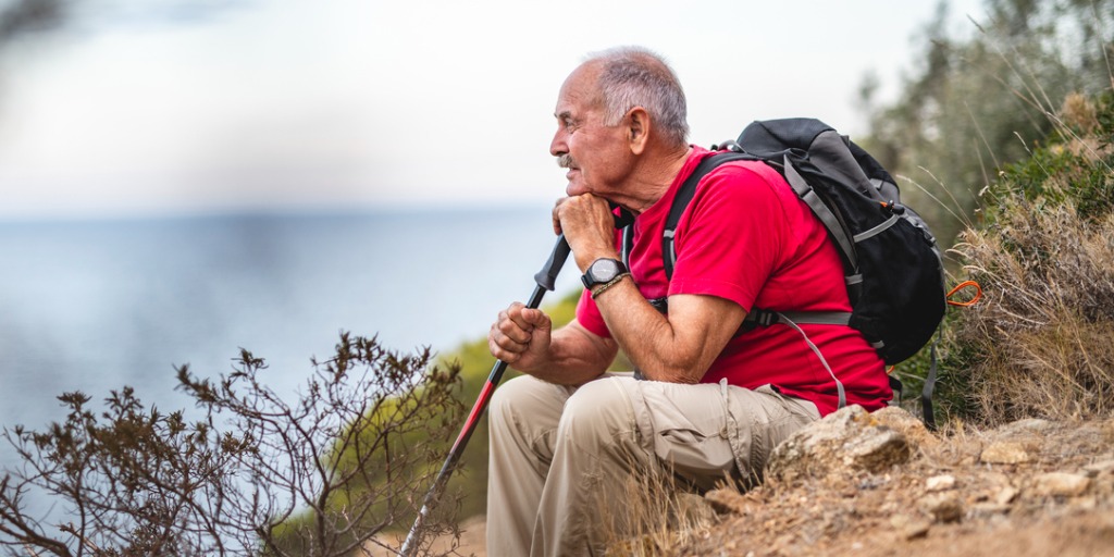 Contemplative senior man taking a break from his hike. Contemplative senior man taking a break from his hike.