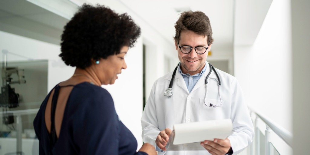 doctor-explaining-medical-exam-to-a-patient-at-hospital-picture-id1197650064