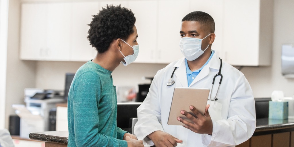 Doctor holding digital tablet and explaining diagnosis to a patient