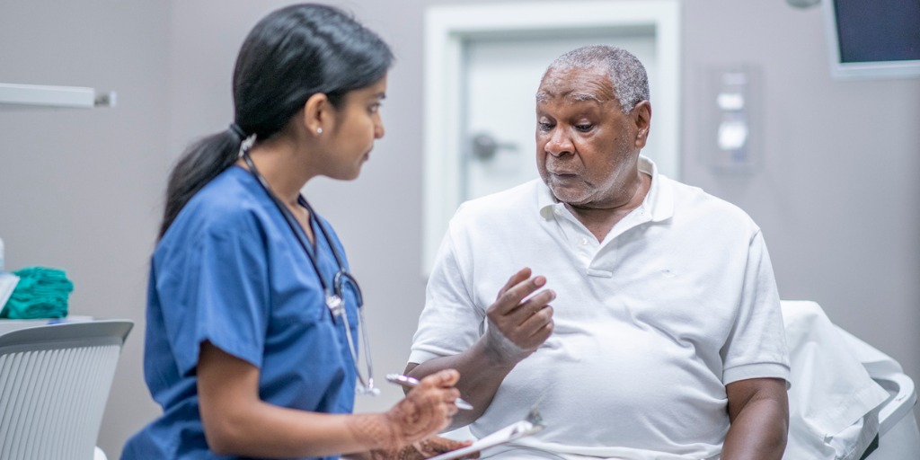 elderly-male-patient-talking-with-female-doctor-stock-photo-picture-id1212821220