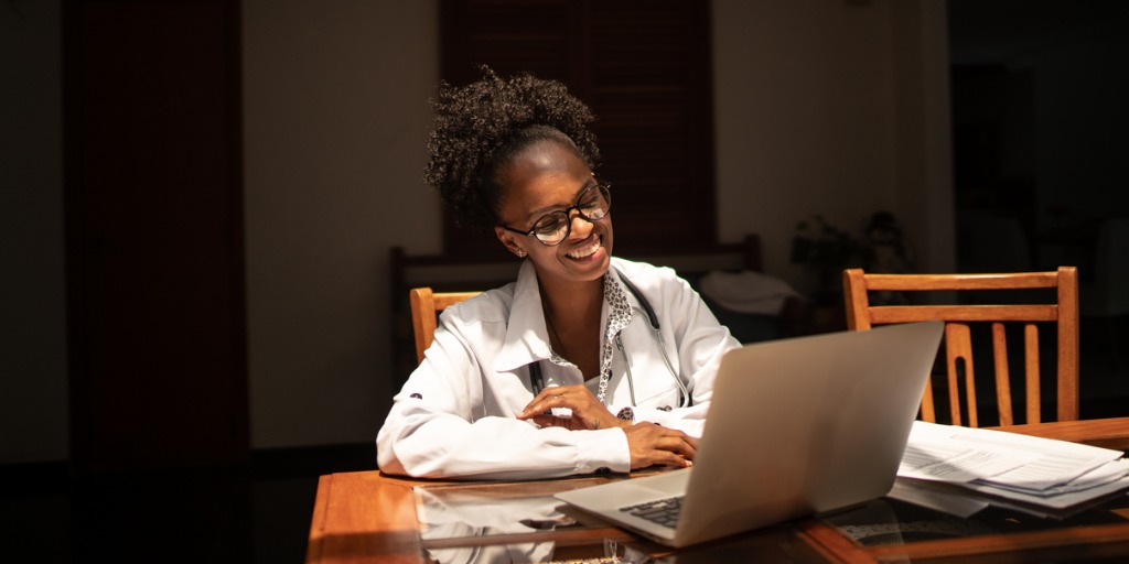 Female doctor using laptop while working from home