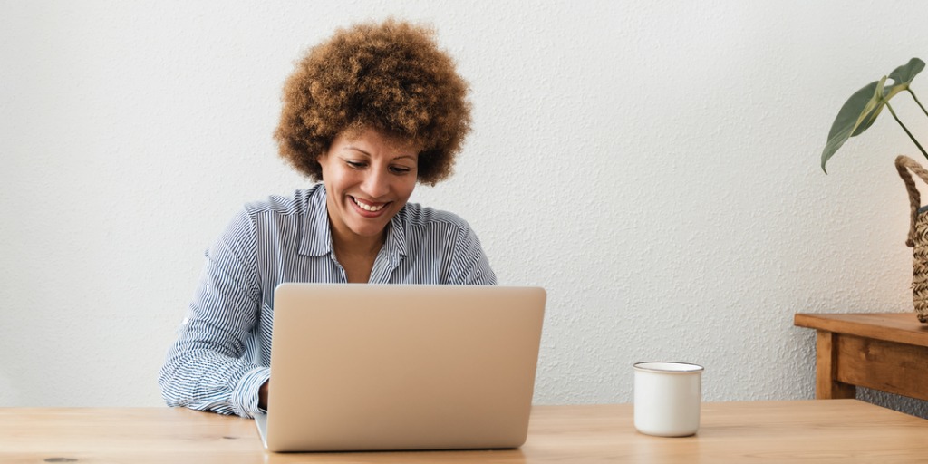 Happy woman working on computer laptop at home office.