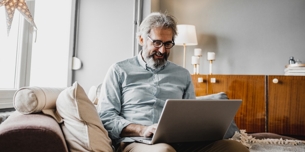 Man using laptop in living room 