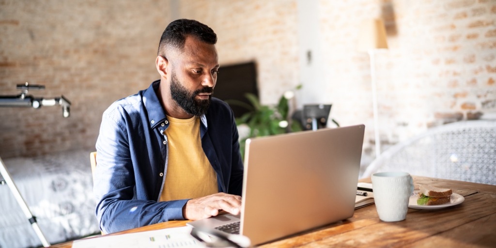 Mature man using laptop at home.