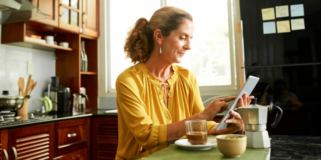 mature-woman-working-on-digital-tablet-picture-id1141120537