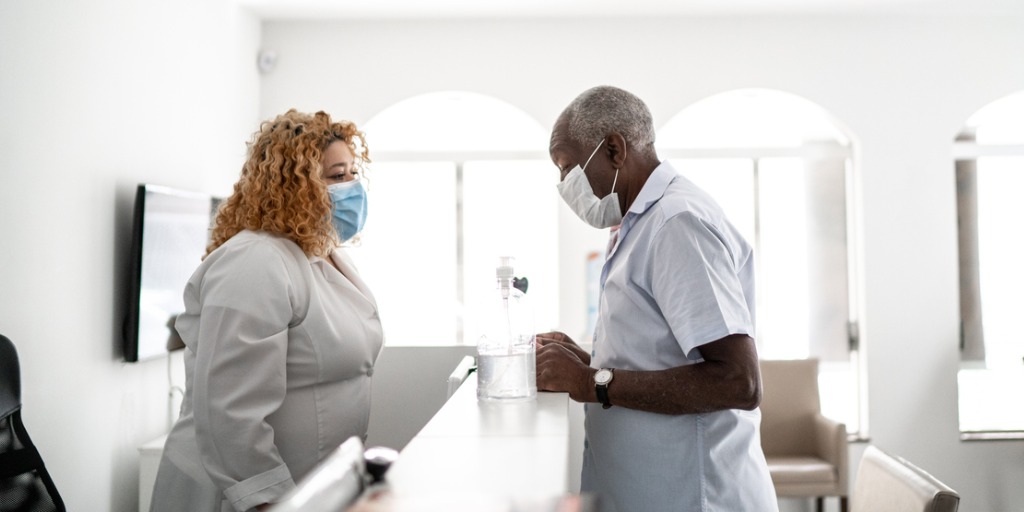 Medical clinic receptionist talking to patient