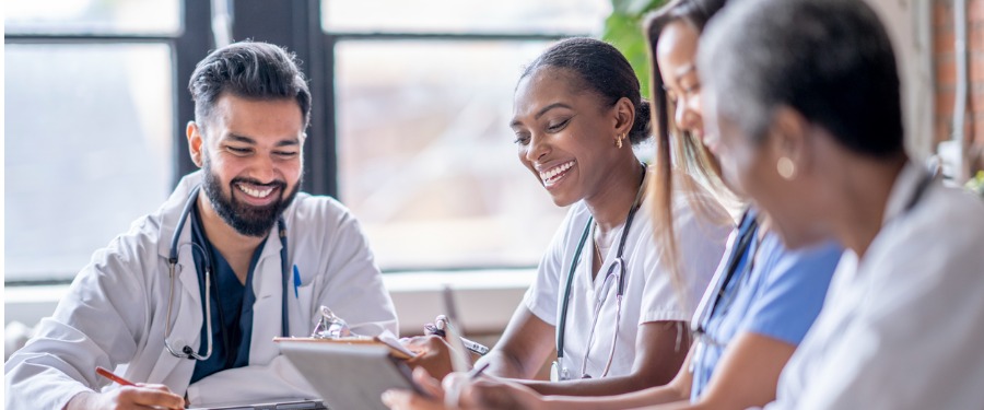 Group of medical professionals smiling and discussing rare disease clinical trials