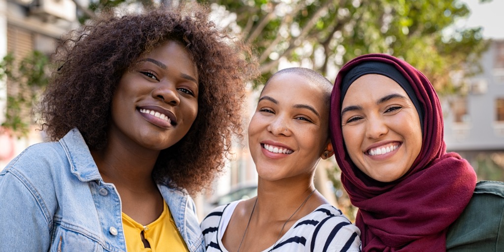 Group of three happy friends looking at camera