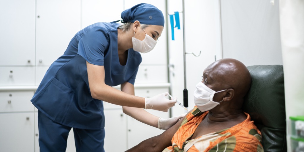 Nurse giving a vaccination shot to a patient Nurse giving a vaccination shot to a patient