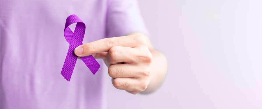 Person’s hand holding a purple ribbon for Lupus Awareness Month