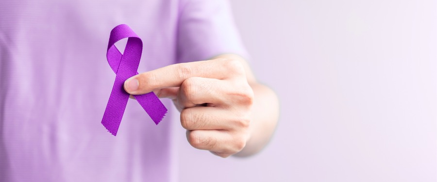 Person’s hand holding a purple ribbon for Lupus Awareness Month Person’s hand holding a purple ribbon for Lupus Awareness Month