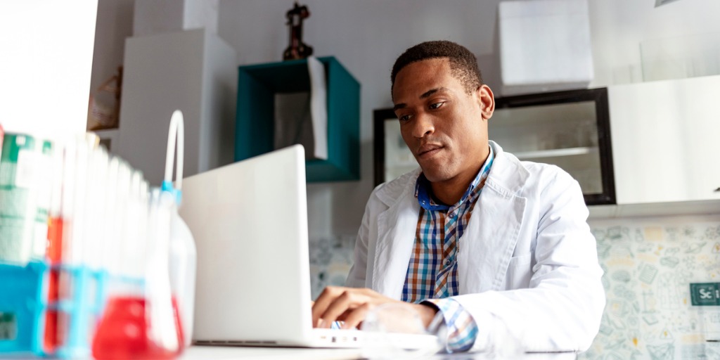 African-American Male scientist working in the laboratory with laptop