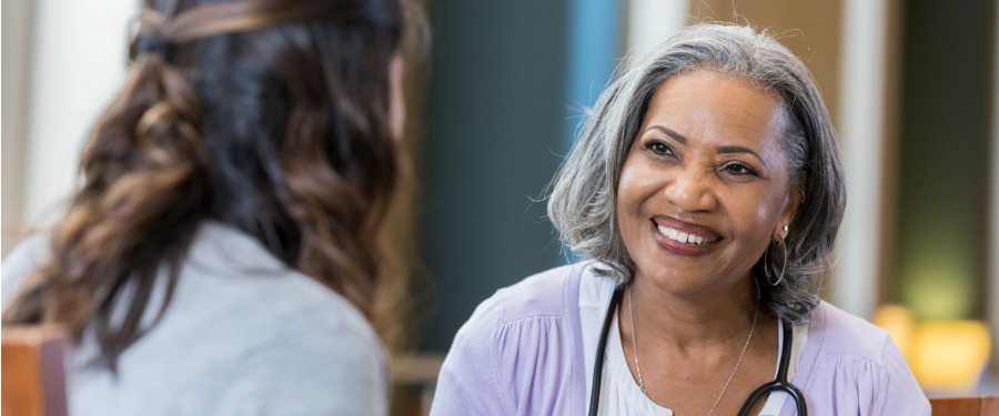 Smiling woman discusses clinical trial site support with second woman