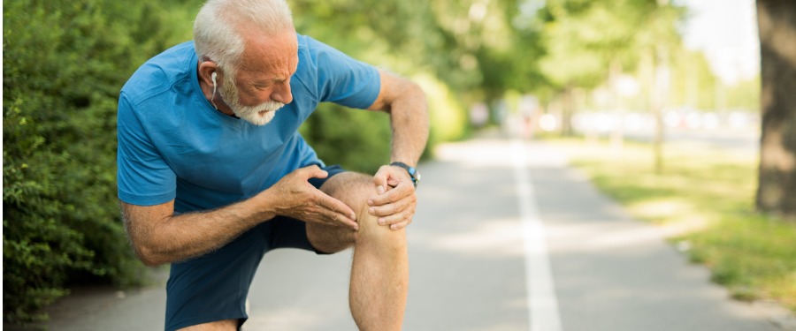 Older man experiencing symptoms of knee osteoarthritis