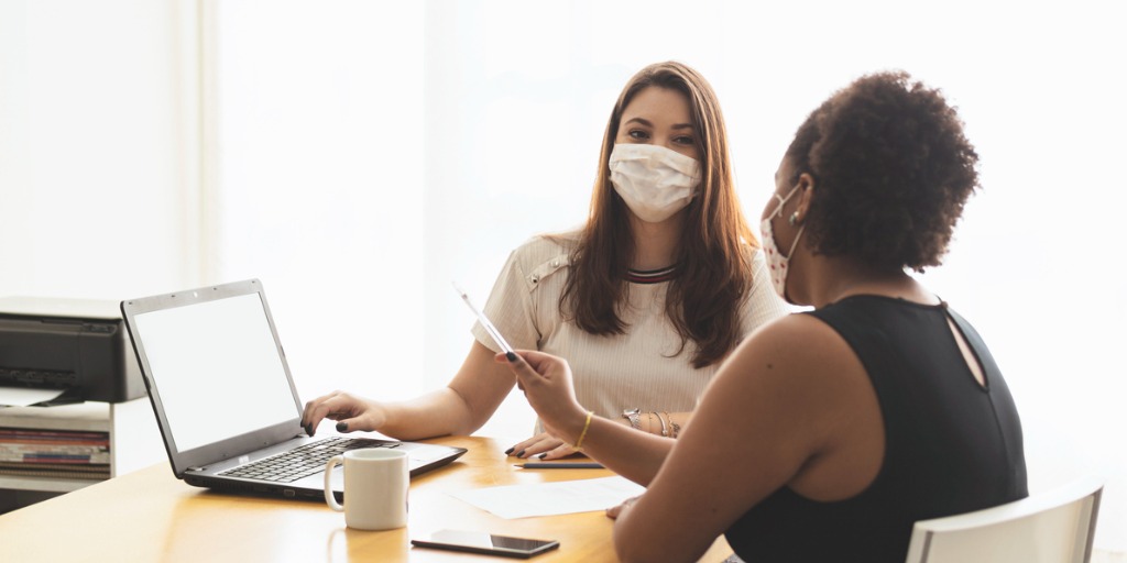 Two female colleagues looking at a laptop in a conference room. Two female colleagues looking at a laptop in a conference room.
