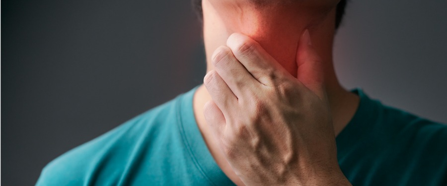 Man holding throat from Eosinophilic Esophagitis pain