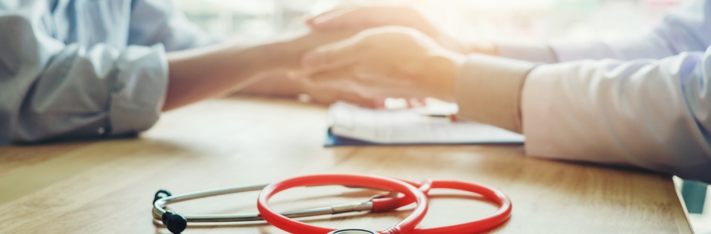 Doctor and patient holding hands while discussing clinical trials